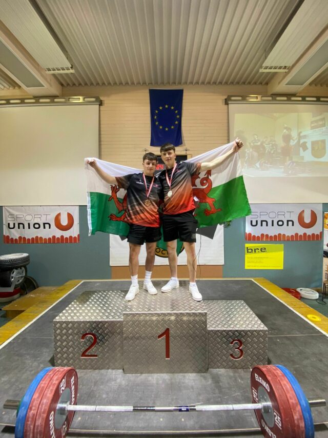 Ben Foggo and Cian Green on the podium with their Welsh flags at the Junior Battle 2022 min