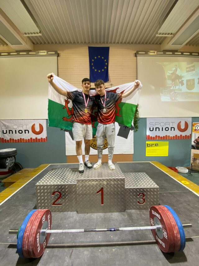 Thomas Hughes and Daniel Davies on the podium with their Welsh flags at the Junior Battle 2022 min